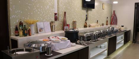 A buffet setup with various food items and condiments.