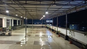 A spacious indoor area with a tiled floor, metal ceiling beams, and potted plants. - Fortune Inn Sree Kanya, Visakhapatnam - Member ITC Hotels' Group (Visakhapatnam)