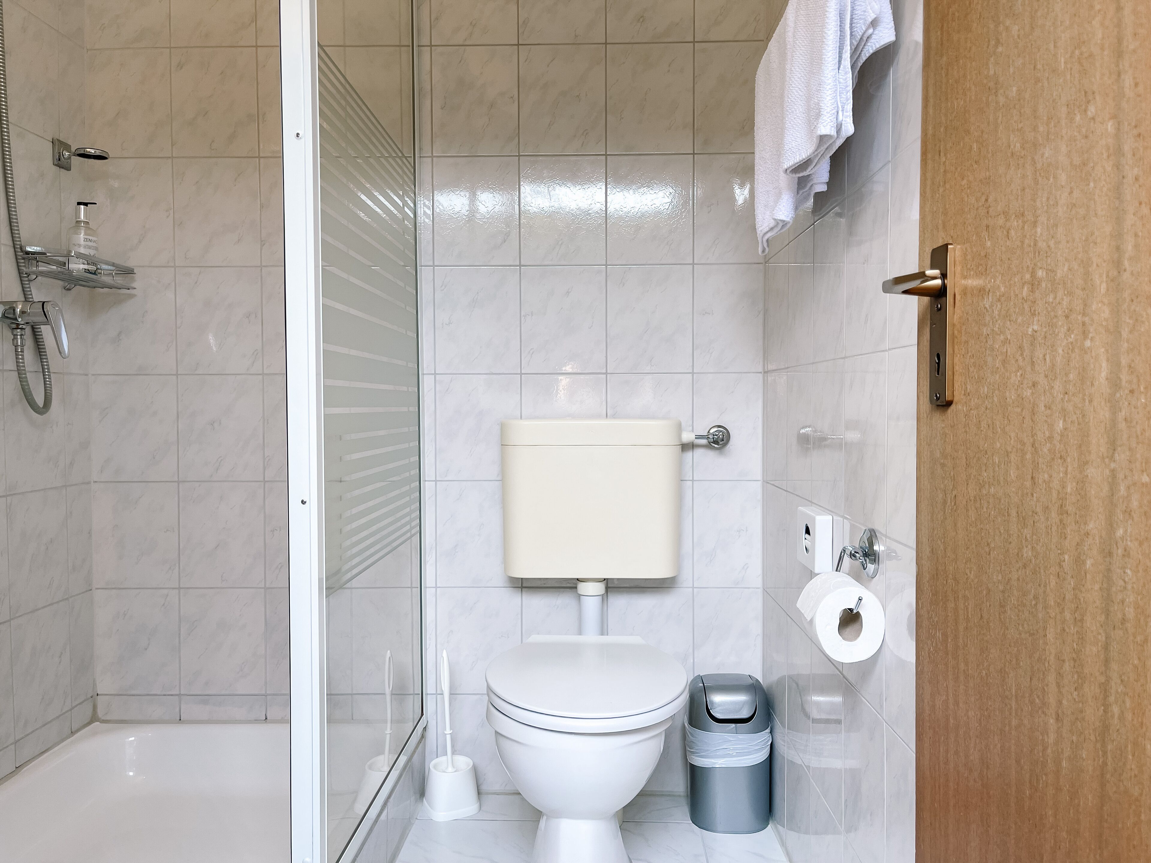 A modern bathroom with a toilet, bidet, and shower.