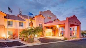 A Fairfield Inn & Suites by Marriott hotel with a modern design, a parking lot, and a landscaped entrance.