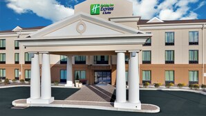 Ein Holiday Inn Express & Suites mit zentralem Eingang, mehreren Fenstern und blauem Himmel.