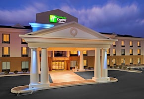 A Holiday Inn Express & Suites with a central entrance pavilion, multiple floors, and a parking area.