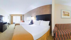 Ein Hotelzimmer mit zwei Betten, einem Fernseher, einem Schreibtisch, einem Stuhl und einem Sofa.