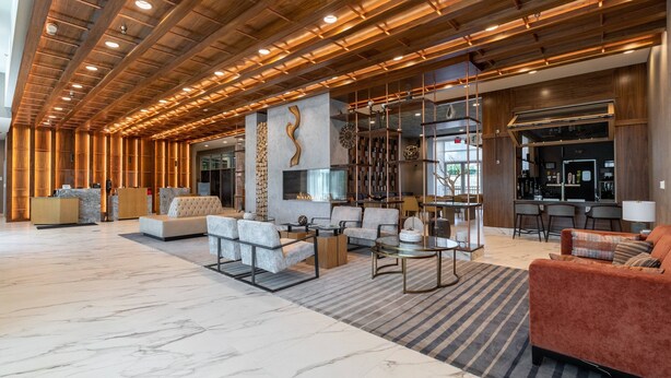 A spacious lobby with a high ceiling, wooden beams, and a central seating area with sofas and a coffee table. - Delta Hotels by Marriott Raleigh-Durham at Research Triangle Park (Durham)