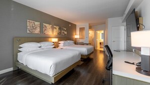 A hotel room with two beds, a desk, a chair, and a TV. - Delta Hotels by Marriott Raleigh-Durham at Research Triangle Park (Durham)