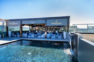 Una piscina al aire libre, sombrillas, sillones reclinables de piscina