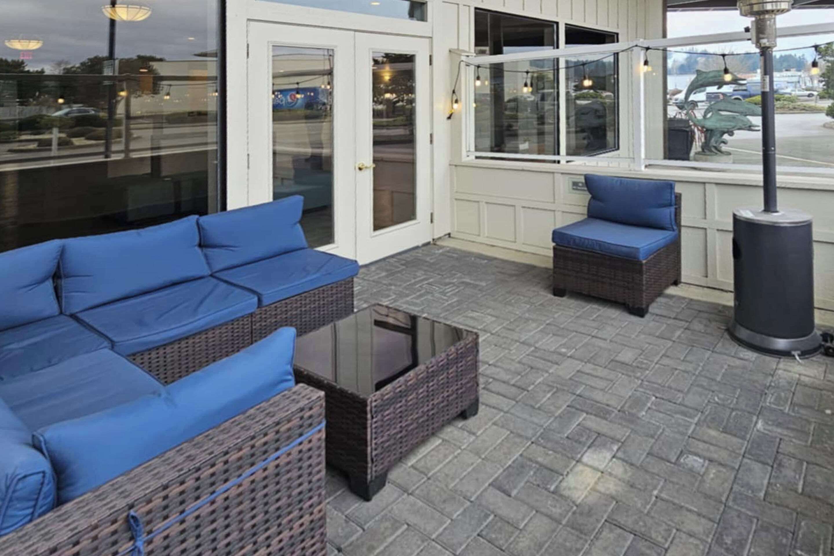 An outdoor seating area with wicker furniture and a glass table.