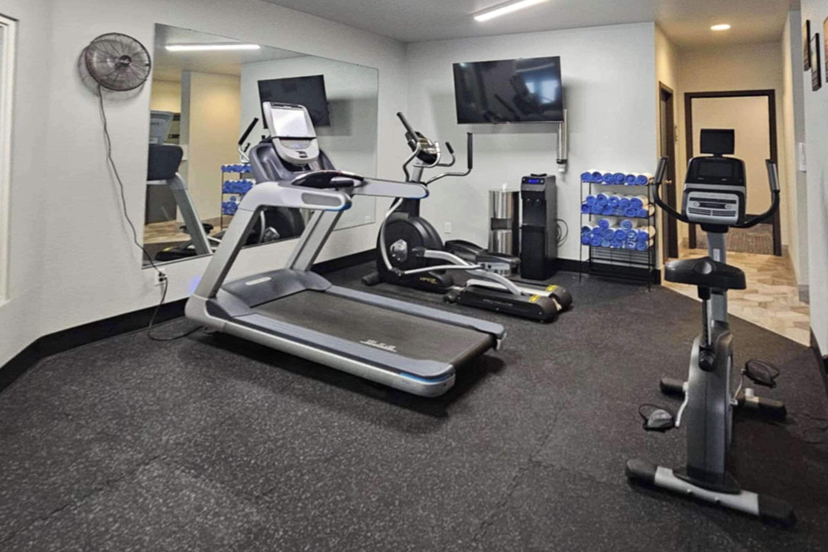 A gym with treadmills, an elliptical, and a stationary bike.