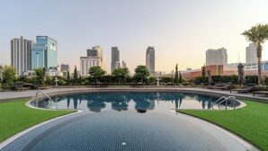 A swimming pool with a city skyline in the background.