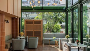 A modern interior with a green-tiled floor, a wooden partition, and a seating area with sofas and tables.
