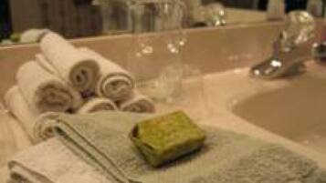 A bathroom with a sink, mirror, and towels.