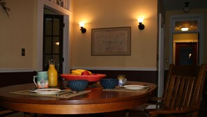 A dining table with chairs, a map on the wall, and a fruit bowl. - Beautiful Valley Guesthouse (Scottsville)