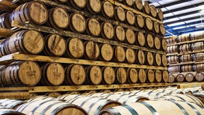 Wooden barrels stacked in a warehouse.