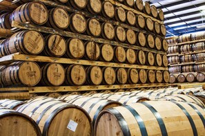 Wooden barrels stacked in a warehouse.
