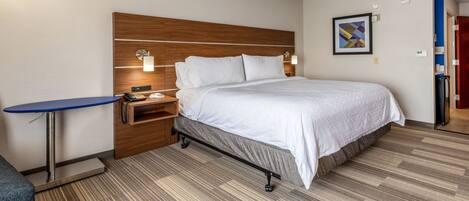 A hotel room with a bed, a desk, and a chair.