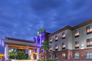 A hotel with a brick facade, a gas station, and a covered parking area. - Holiday Inn Express Picayune-Stennis Space Center by IHG (Picayune)
