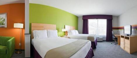 A hotel room with two beds, a desk, a chair, a TV, and a lamp.