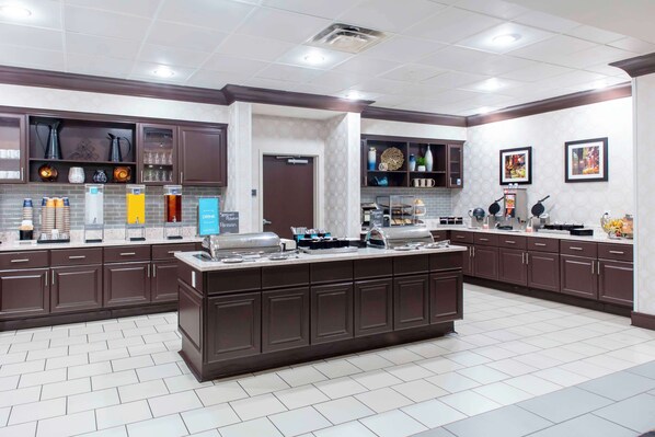 Una cocina moderna con armarios de madera oscura, una isla central y varios electrodomésticos.