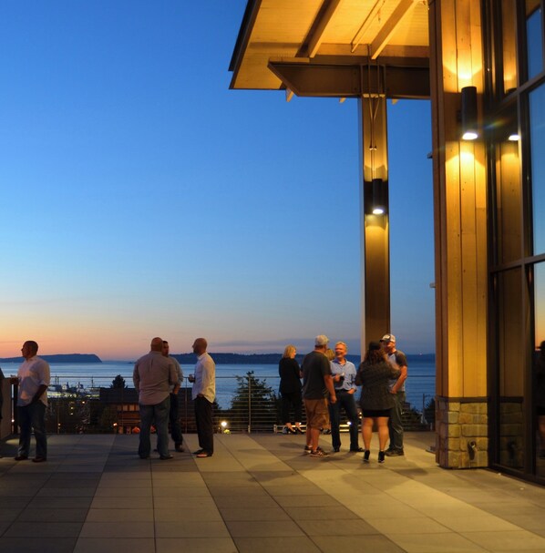 A group of people standing on a terrace with a view of the water. - Staybridge Suites Everett-Paine Field by IHG (Mukilteo)