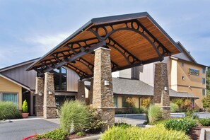 A hotel with a covered entrance, stone pillars, and a sign for 'Staybridge Suites.' - Staybridge Suites Everett-Paine Field by IHG (Mukilteo)