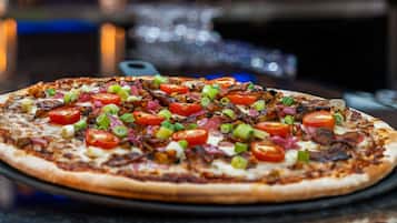 En pizza med forskellige toppings på en sort tallerken.