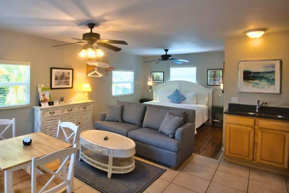 Un espacio habitable compacto con comedor, sofá, cama y kitchenette.