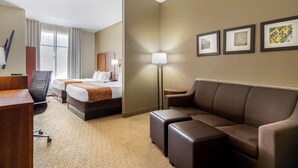 A hotel room with a bed, two bedside tables, a desk, a chair, a sofa, and a lamp. - Comfort Suites Pflugerville - Austin North (Pflugerville)