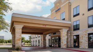 A hotel with a covered entrance, stone pillars, and a sign for Comfort Suites. - Comfort Suites Pflugerville - Austin North (Pflugerville)