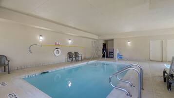 Una piscina techada, sillones reclinables de piscina