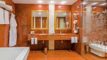 A bathroom with two sinks, a large mirror, a glass shower enclosure, and a bathtub.