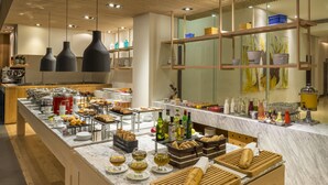 A modern breakfast buffet with a variety of food items, beverages, and a marble countertop. - NH Collection Guadalajara Providencia (Guadalajara)