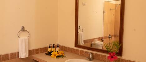 A bathroom with a sink, mirror, towel rack, and toiletries.