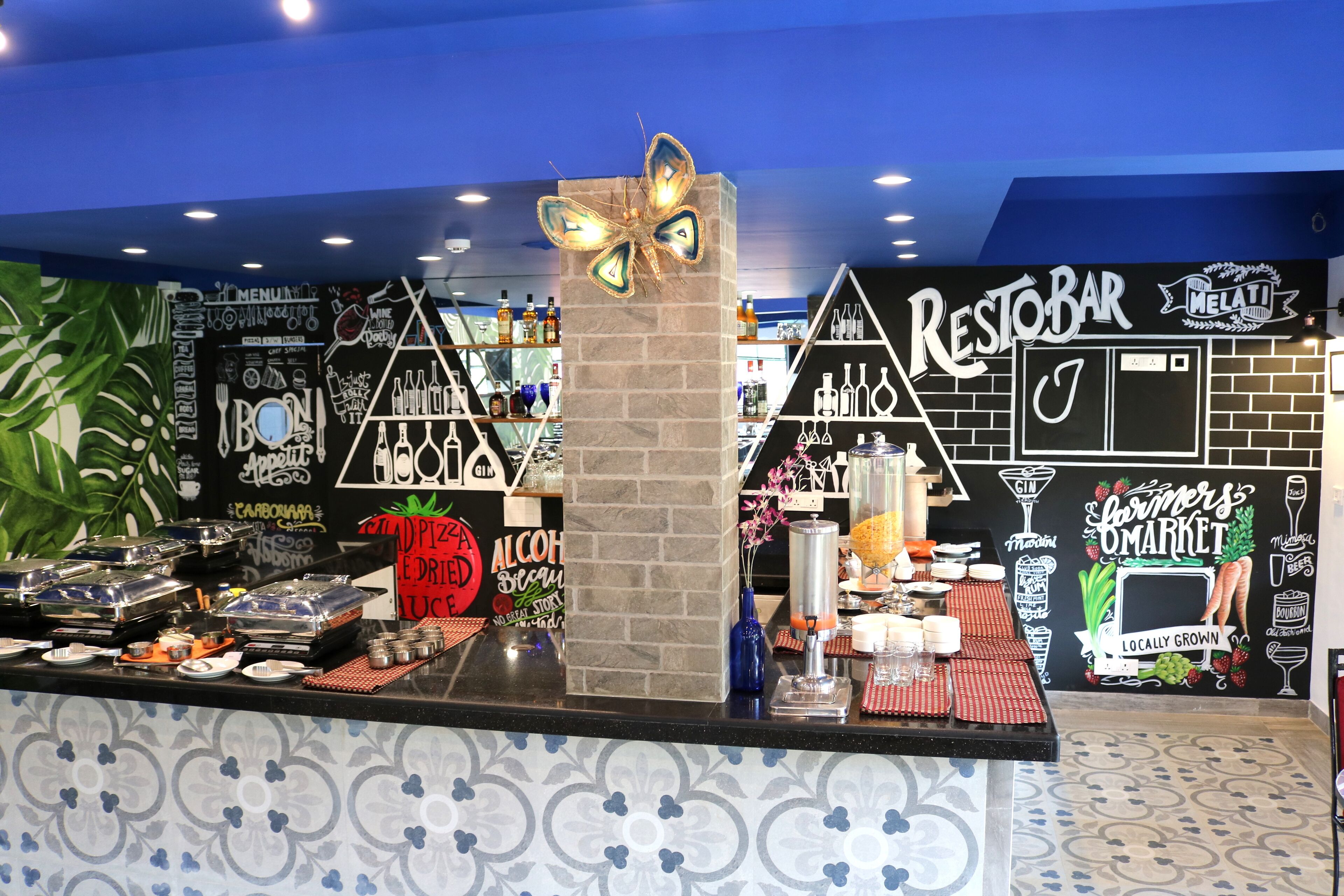 A bar area with a black and white design, a decorative butterfly, and various bottles and glasses.