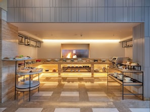 Una cocina moderna con una isla central, diversos electrodomésticos de cocina y un mostrador tipo bufé.