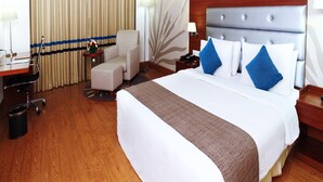 A hotel room with a large bed, a desk, a chair, and a nightstand. - Hotel Abu Palace - Chennai (Chennai)