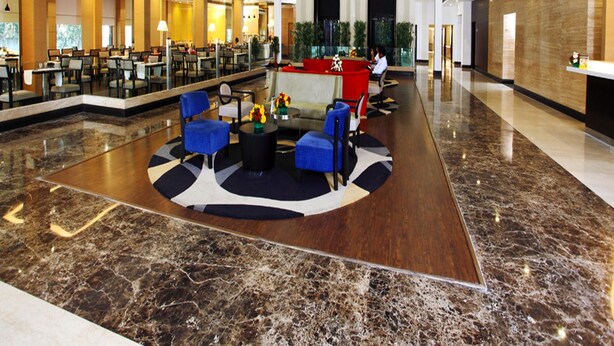A spacious lobby with a central seating area, multiple dining tables, and a high ceiling with large windows. - Hotel Abu Palace - Chennai (Chennai)