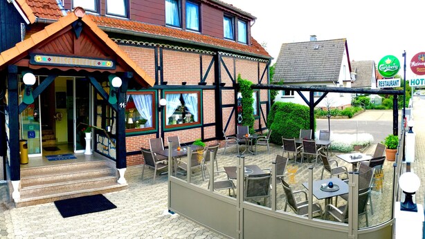 A restaurant with outdoor seating, a brick facade, and a sign indicating it is a restaurant. - Hotel Kaiserquelle (Salzgitter)
