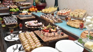 Un bufé con diversos postres y frutas.