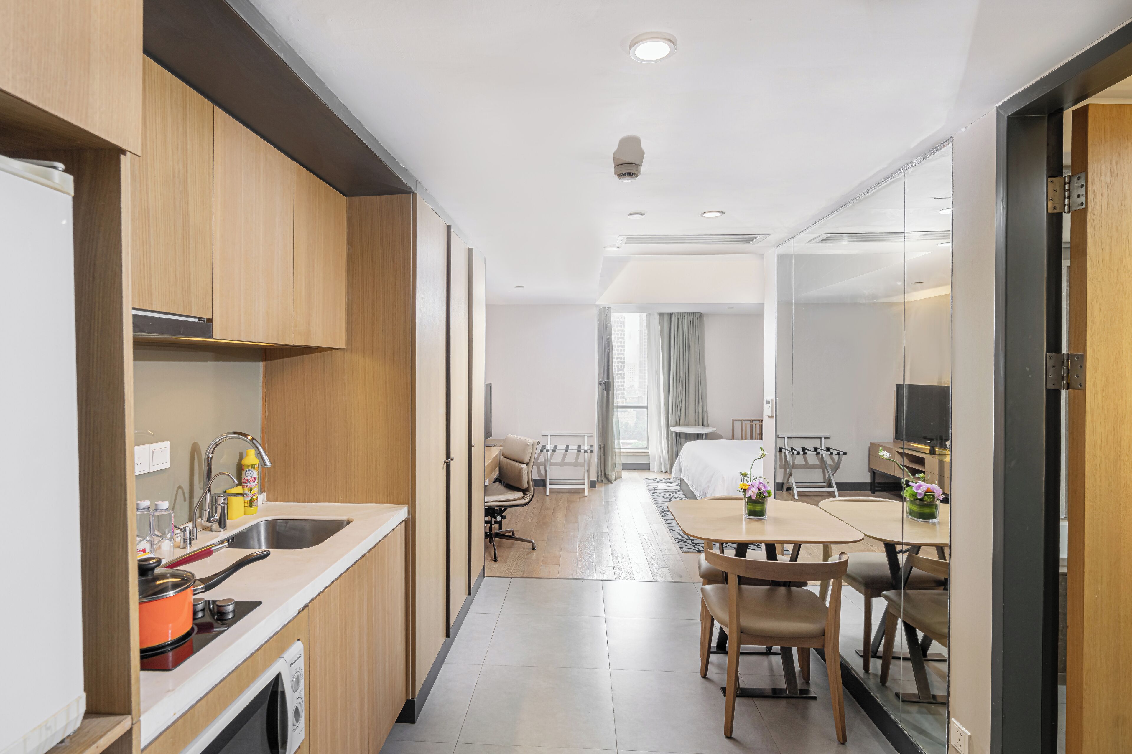 A modern kitchen with a dining area, wooden cabinets, and a small dining table with chairs.