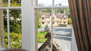 A window with a view of a building and a road. - Three Ways House Hotel (Chipping Campden)