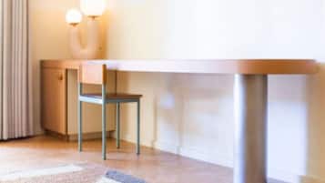 A room with a wooden desk, a chair, and a lamp.
