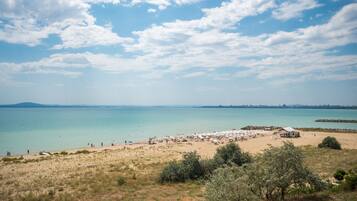 Playa en los alrededores, playa de arena blanca, camastros y sombrillas