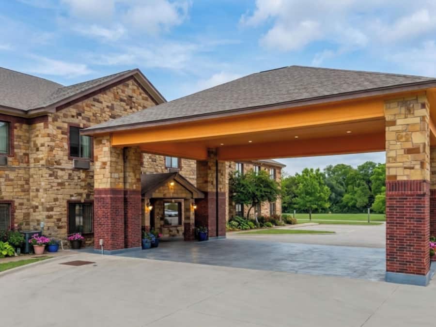 A stone building with a covered entrance and a paved driveway.