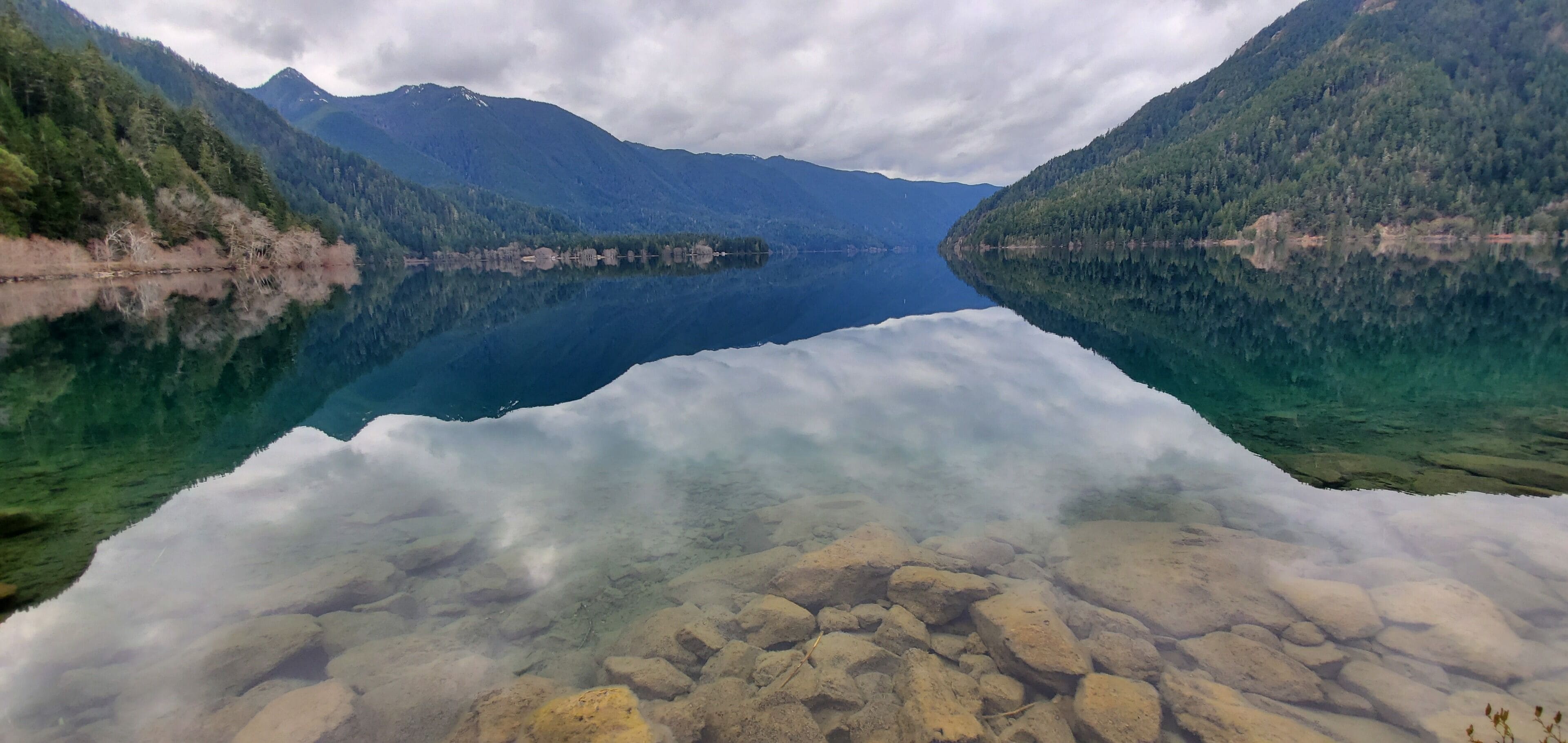Un lago transparente rodeado de montañas.