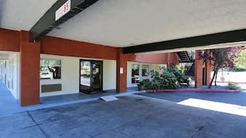 Welcome to this charming building with a covered entrance area, flanked by two columns and a glass door.