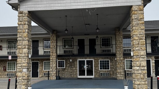 A two-story building with stone pillars, a covered entrance, and multiple windows. - General Bragg Inn & Suites Chickamauga (Chickamauga)