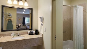 Une salle de bain avec un lavabo, un miroir et une douche.