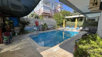 Piscine extérieure, parasols de plage, chaises longues