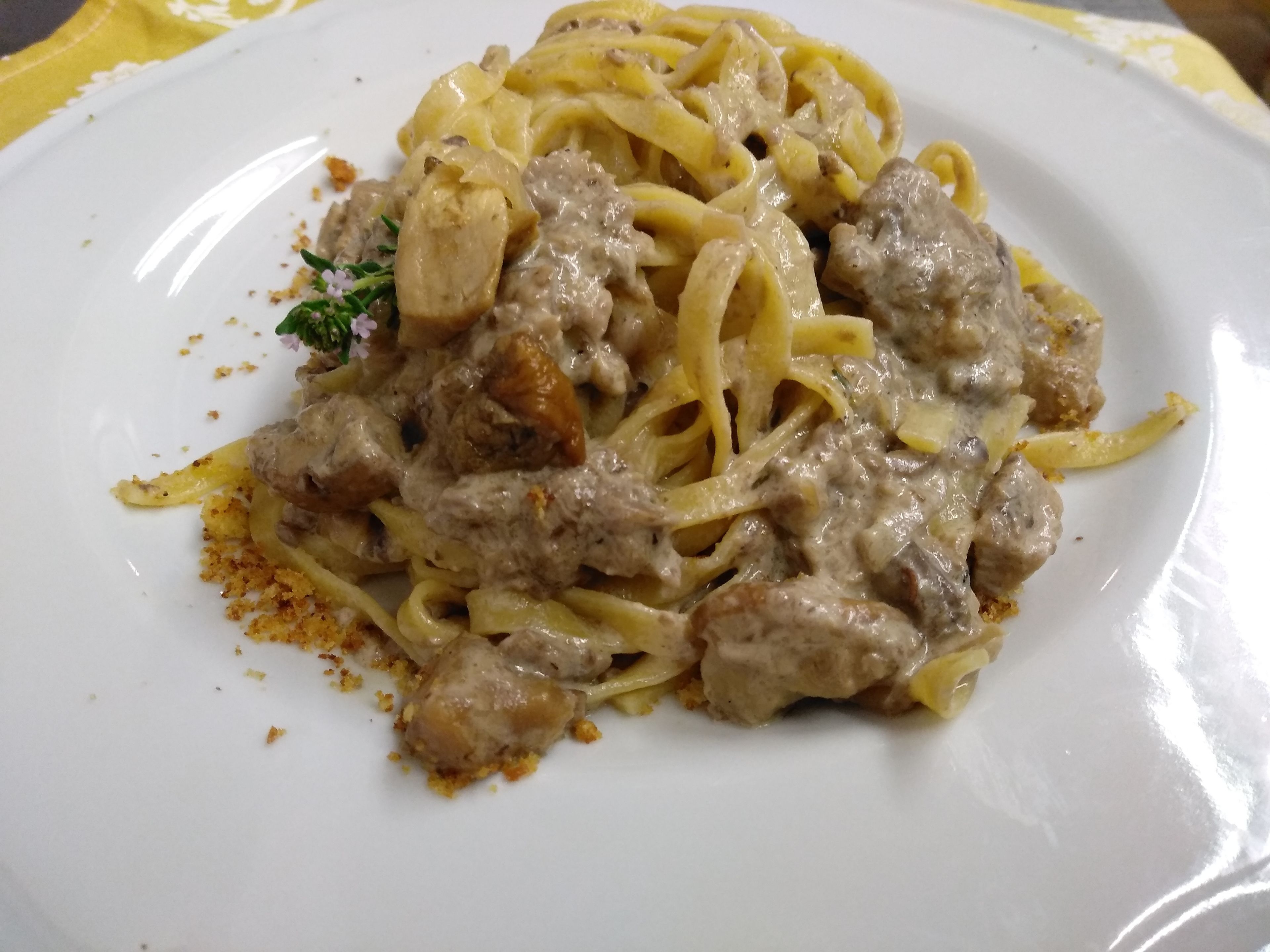 Un plato de pasta con salsa cremosa y carne.