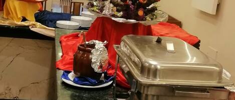 A buffet setup with covered food containers and a decorative centerpiece.